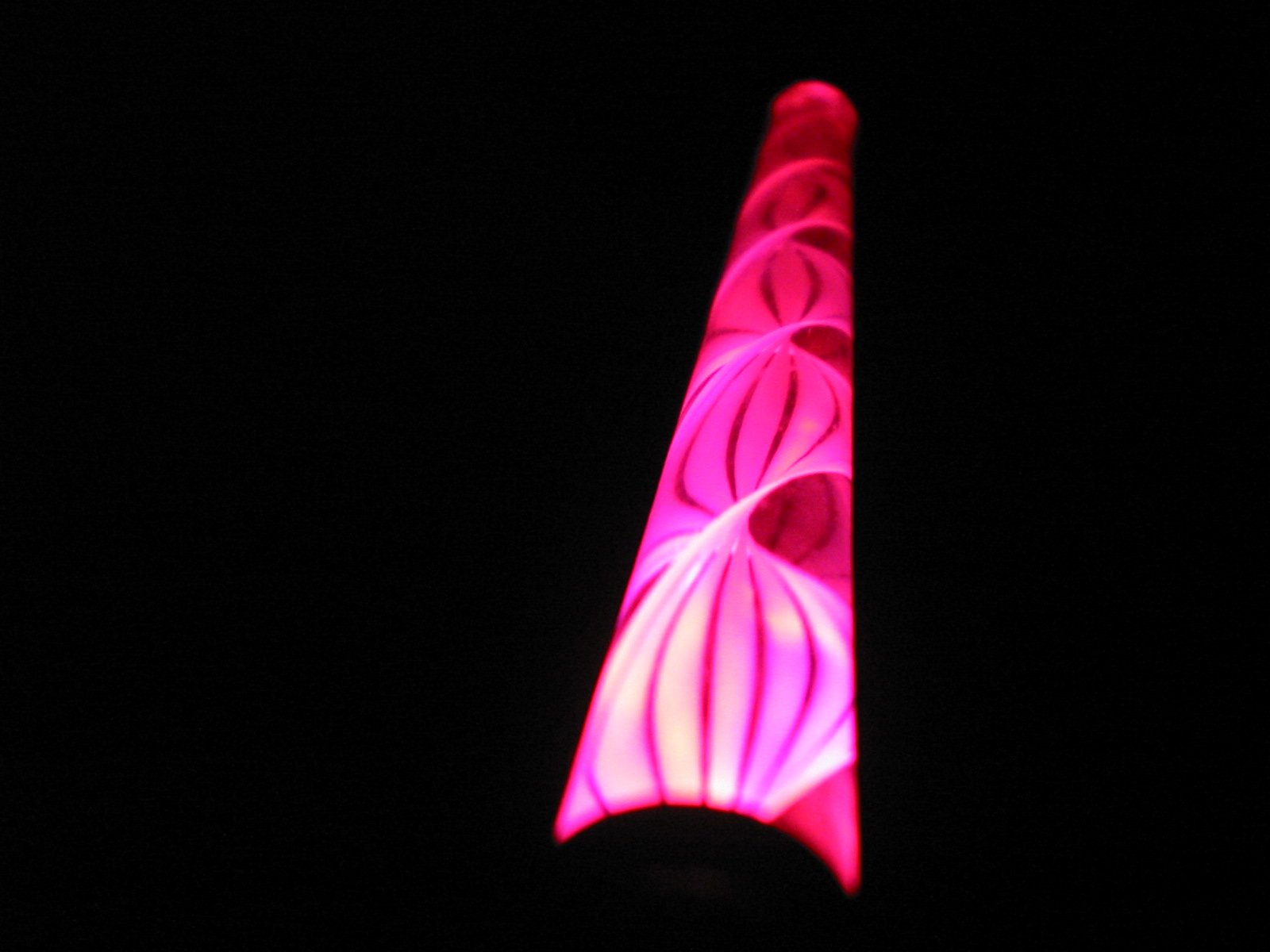 a pink light glows against the dark black sky