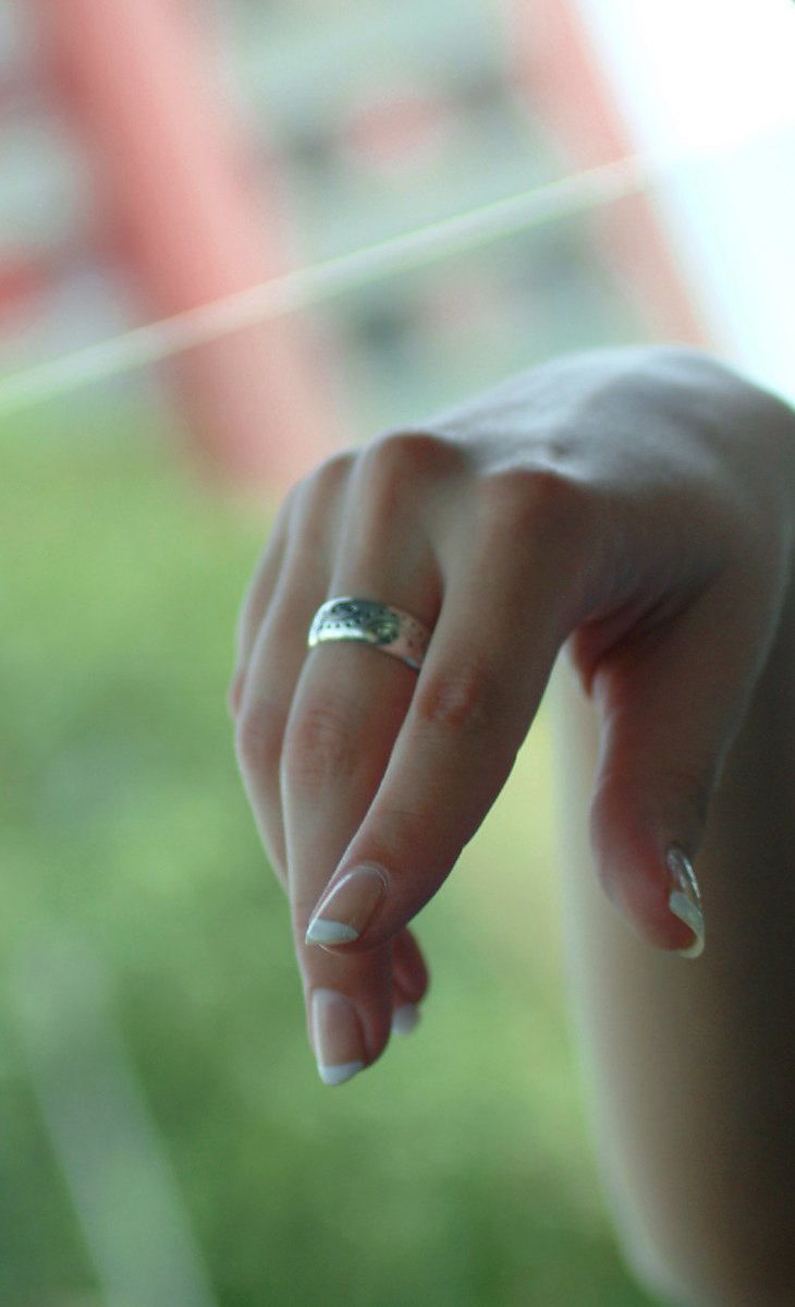 a woman is holding up her finger wearing a ring