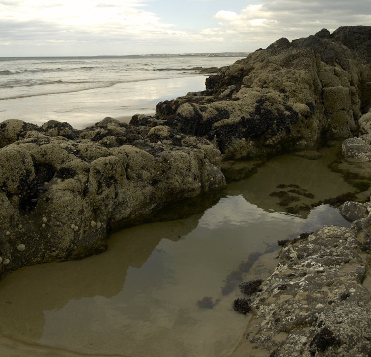 a couple of large rocks sitting on top of a beach