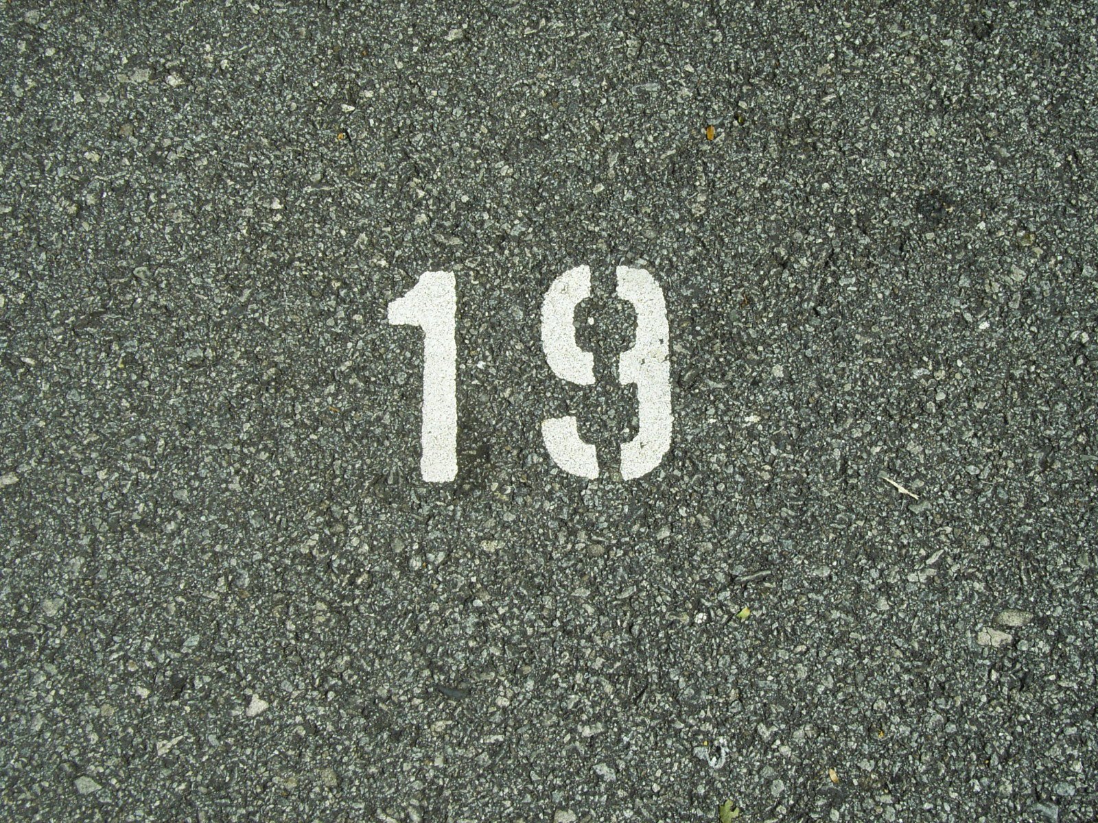 a close up of the number nineteen painted on a street