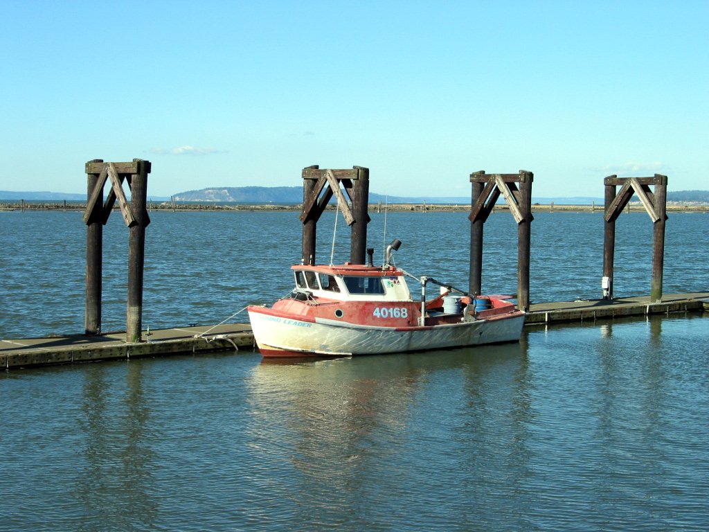 two boats tied to the pier with no people aboard