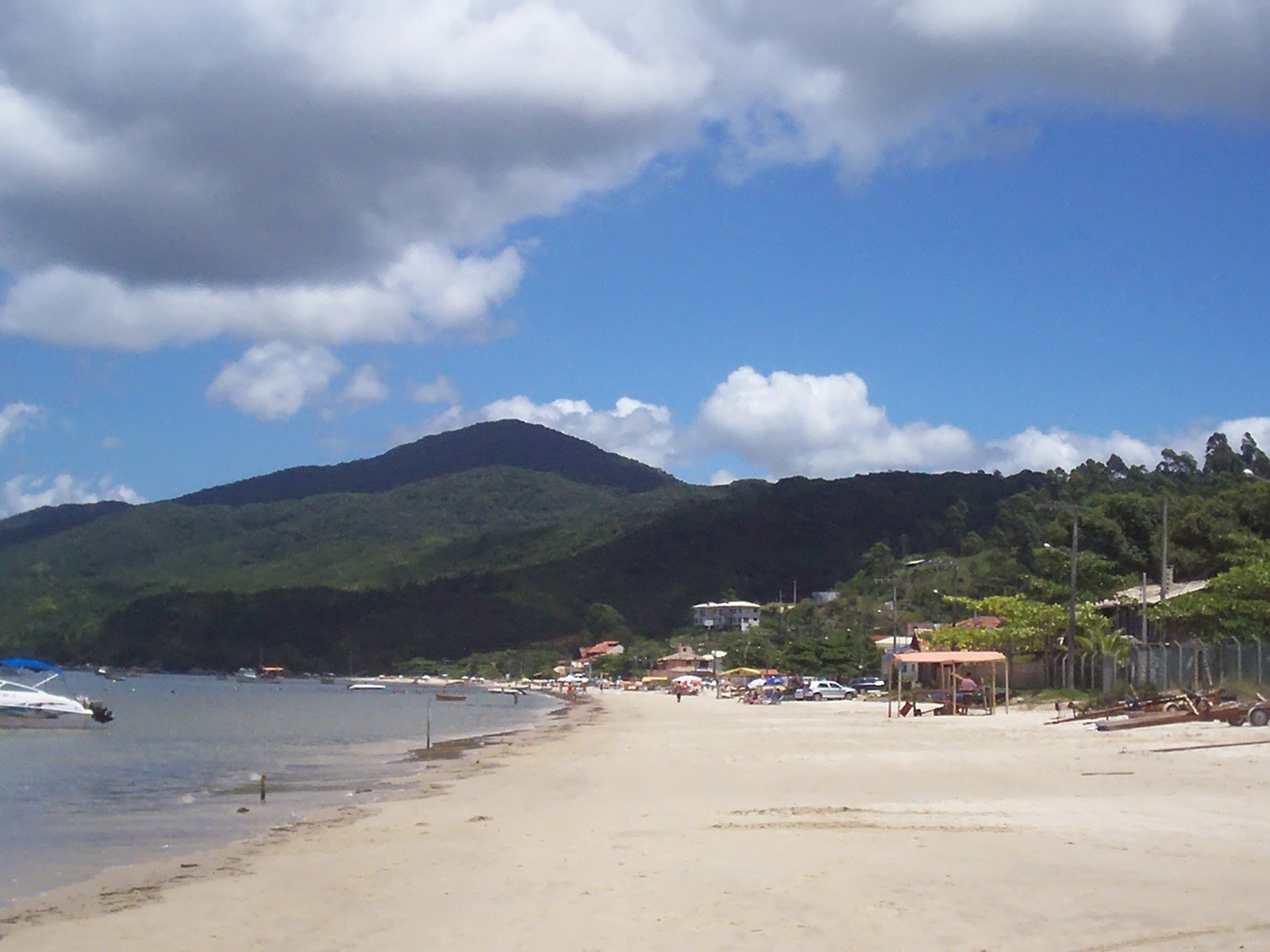 the view from the shore of a beach and sailboats