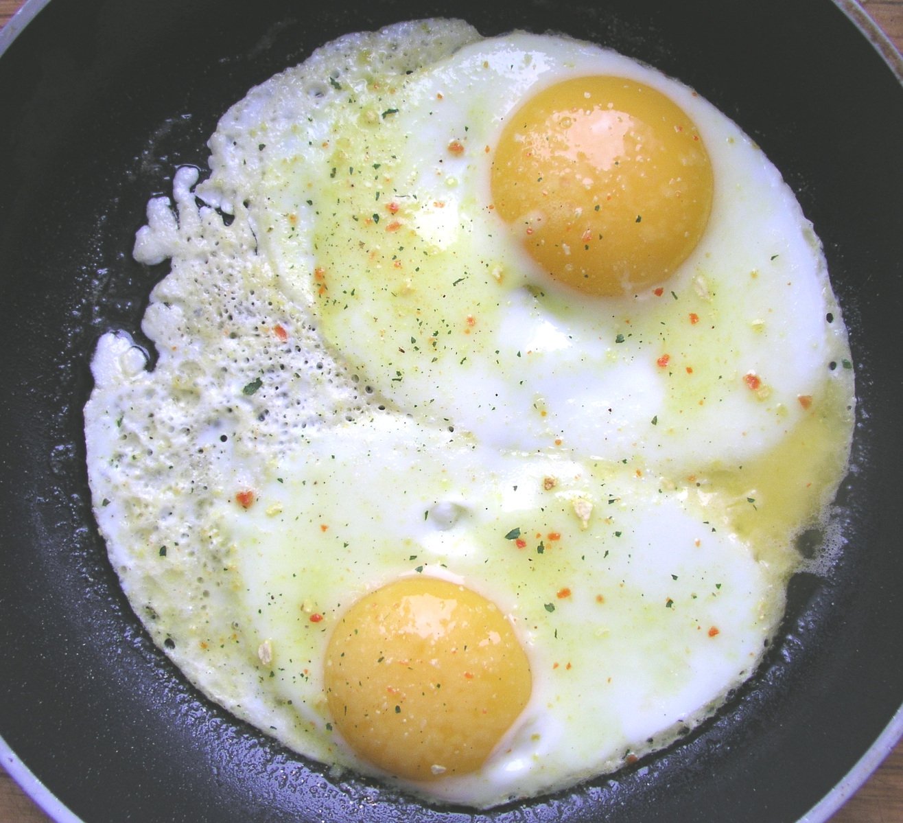 two eggs on top of each other in a pan