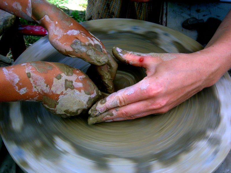 a pair of hands that are sitting on a potter's wheel