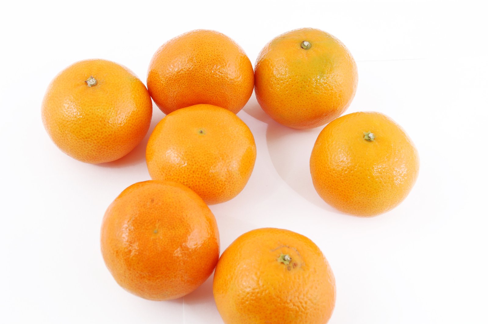 five oranges of various sizes sitting on a table