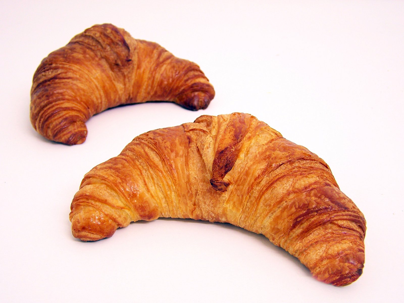 two croissants sitting next to each other on a table
