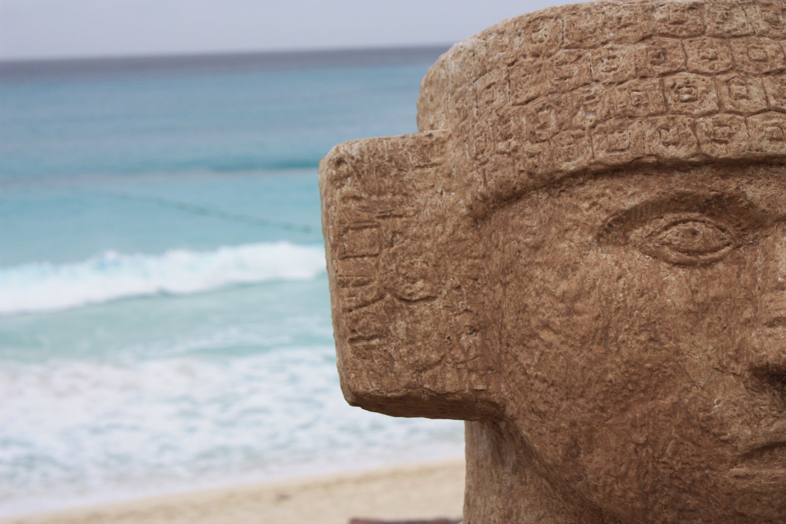 a sculpture near the water has faces