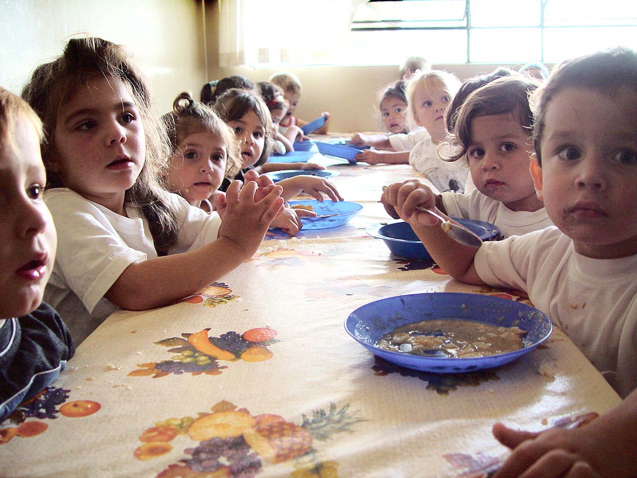 several children are sitting at a table and eating