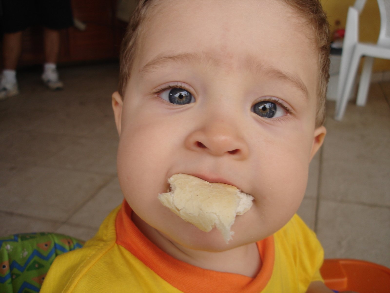 a young child wearing yellow is eating soing