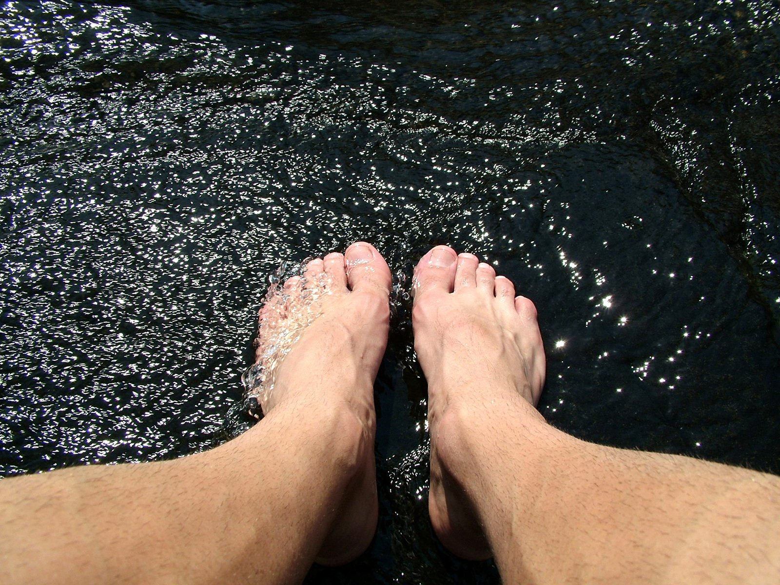 a close up view of two people standing in shallow water