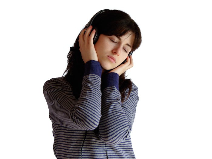 a woman with headphones is holding her ears to her side