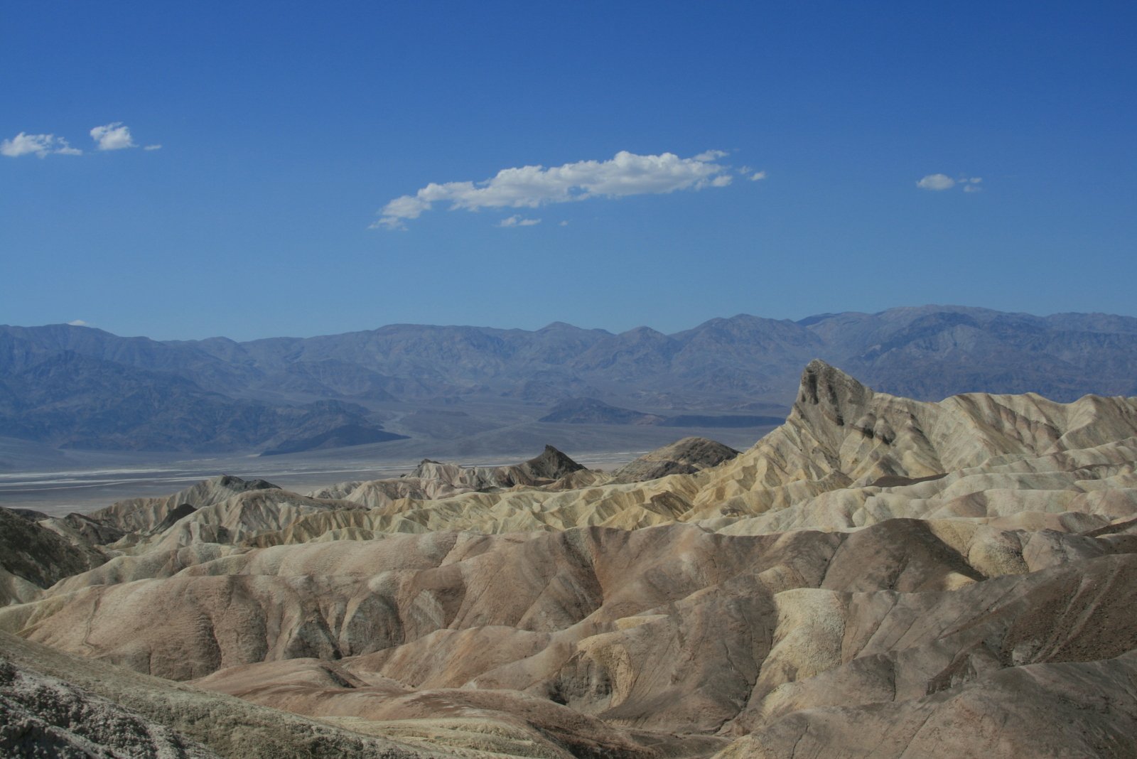 the mountains are in the distance as an airplane flies low