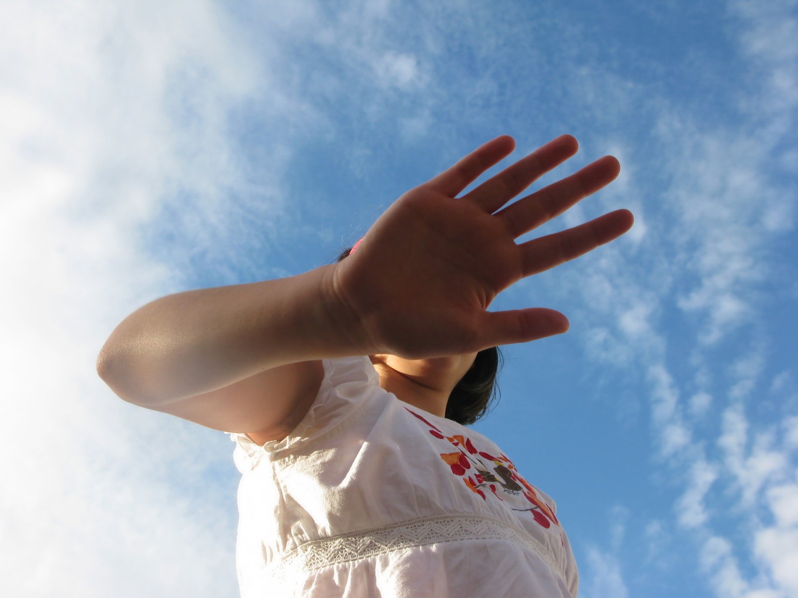 girl with open arms reaching up to sky