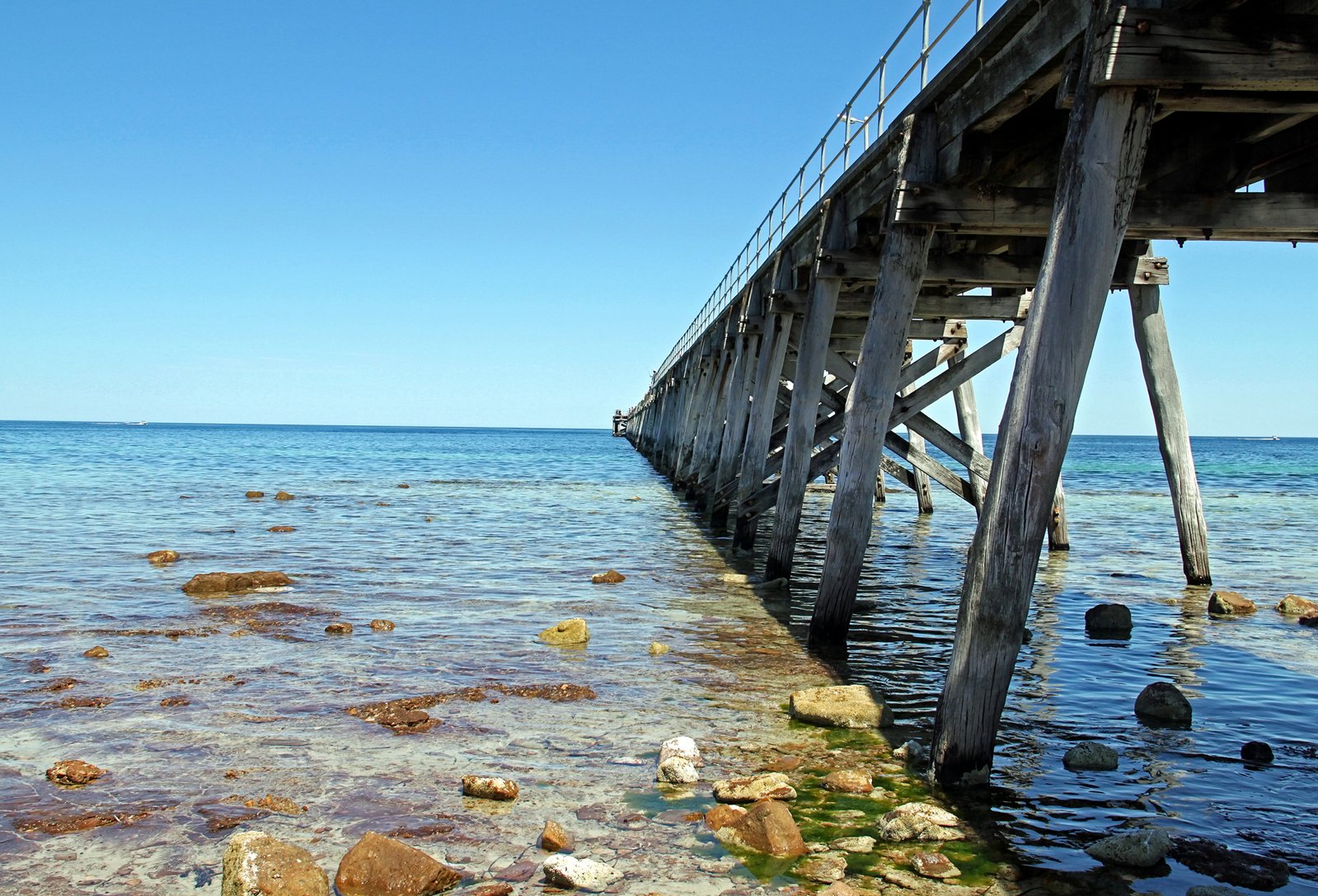 water flowing under a wooden dock on the ocean