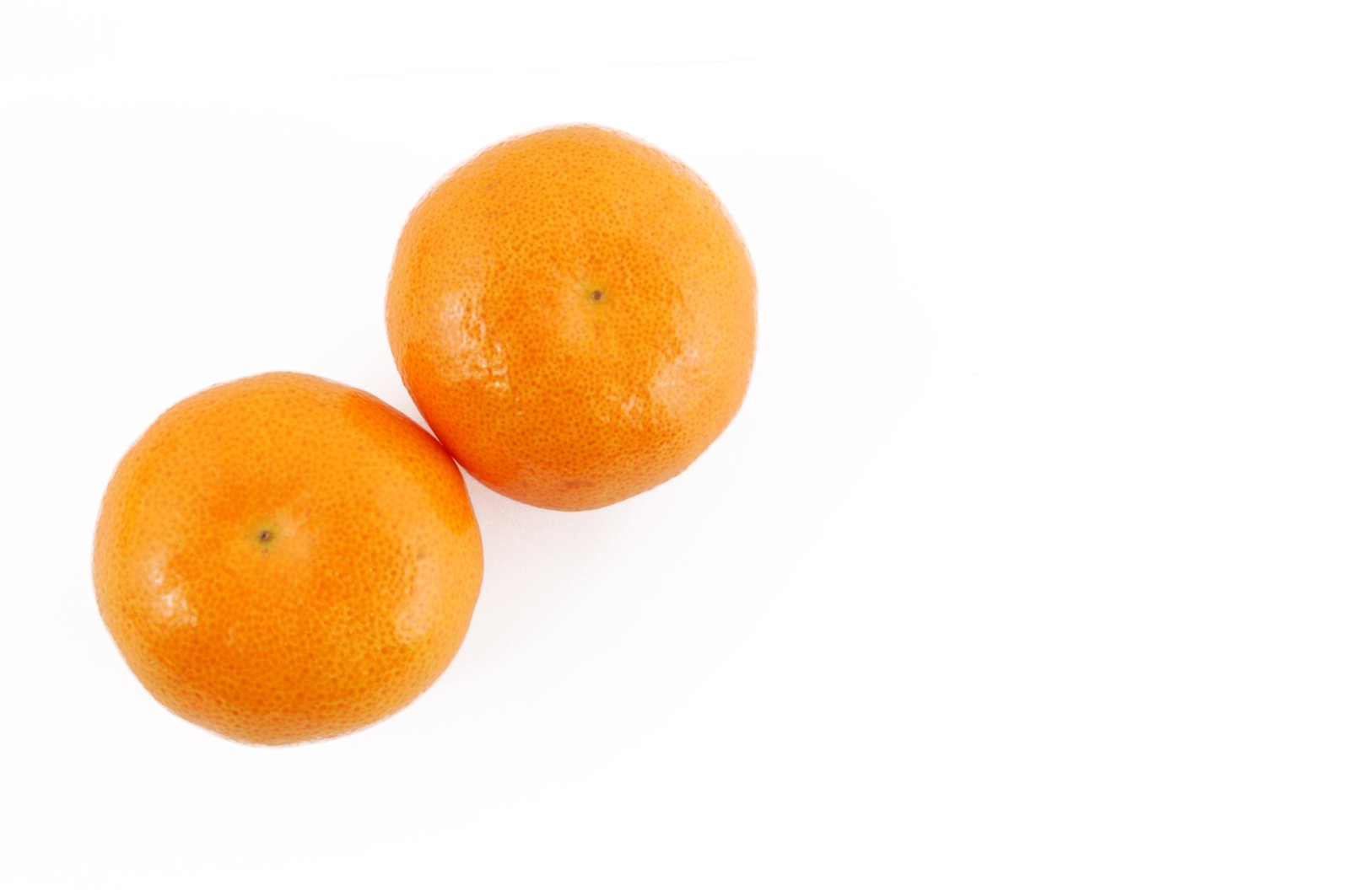 a couple of oranges are sitting on a white table