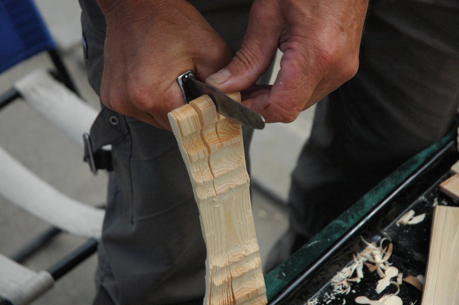 a person uses a knife to cut through wood