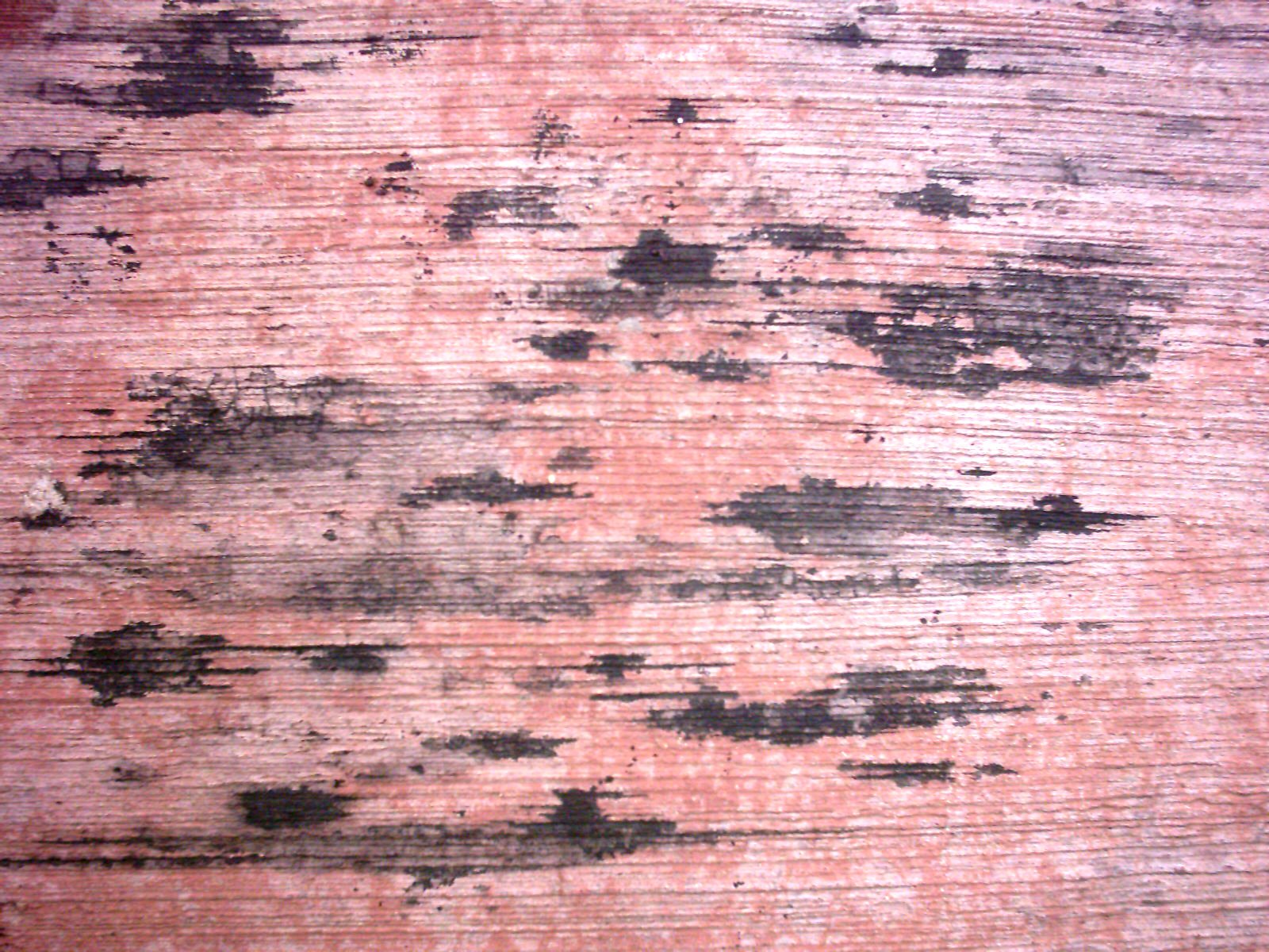 an old, stained wood background with black and pink streaks