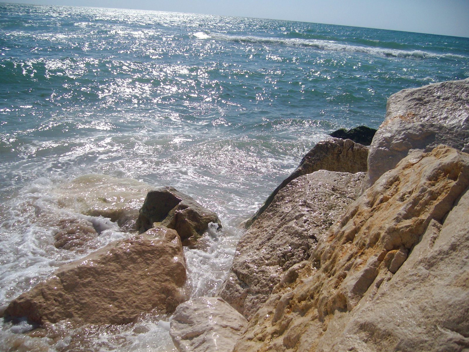 a sea wall with waves crashing in to shore