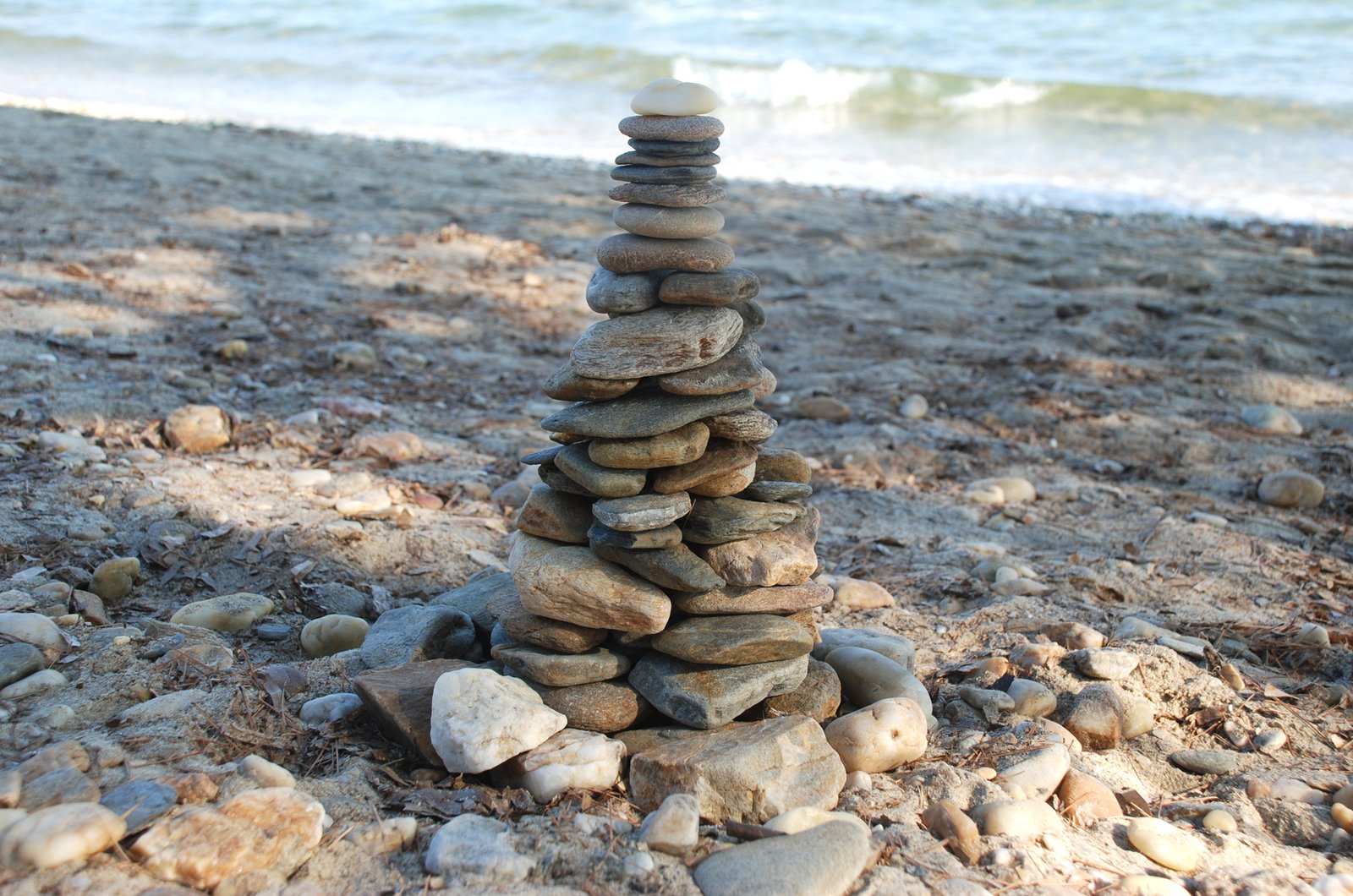 rocks stacked on top of each other next to the water