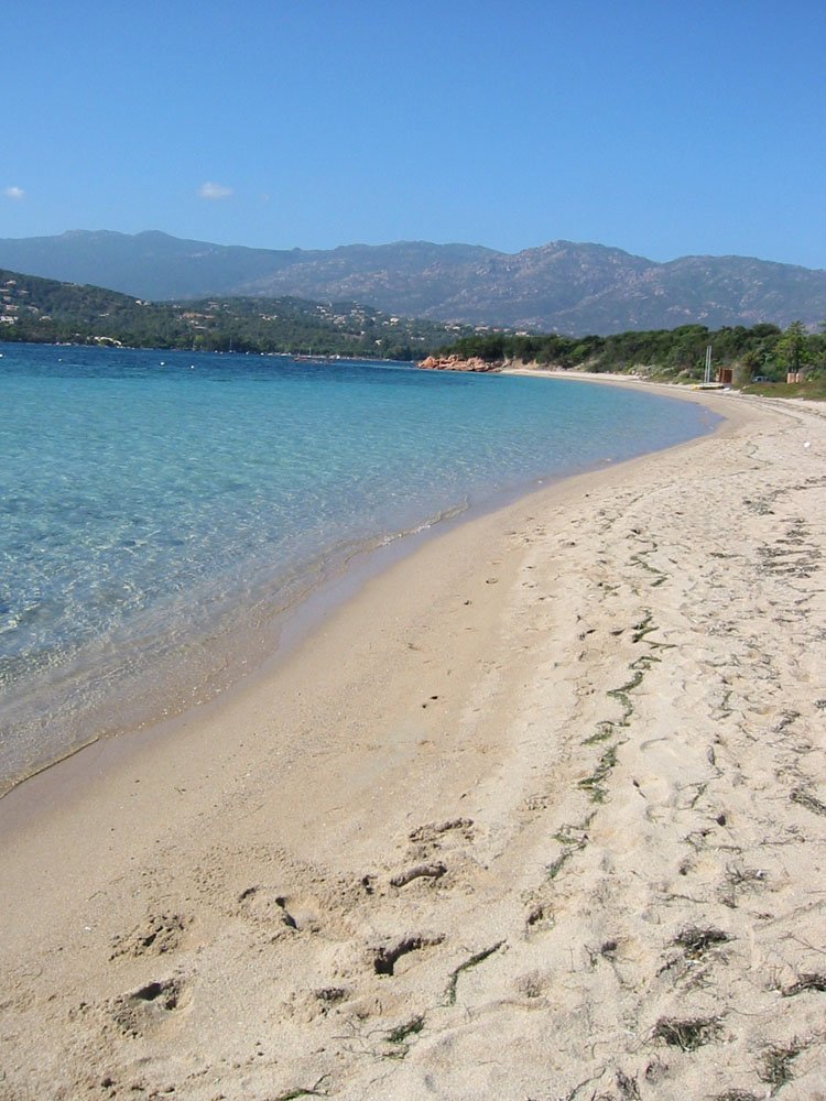 the water is crystal blue in the middle of a beach