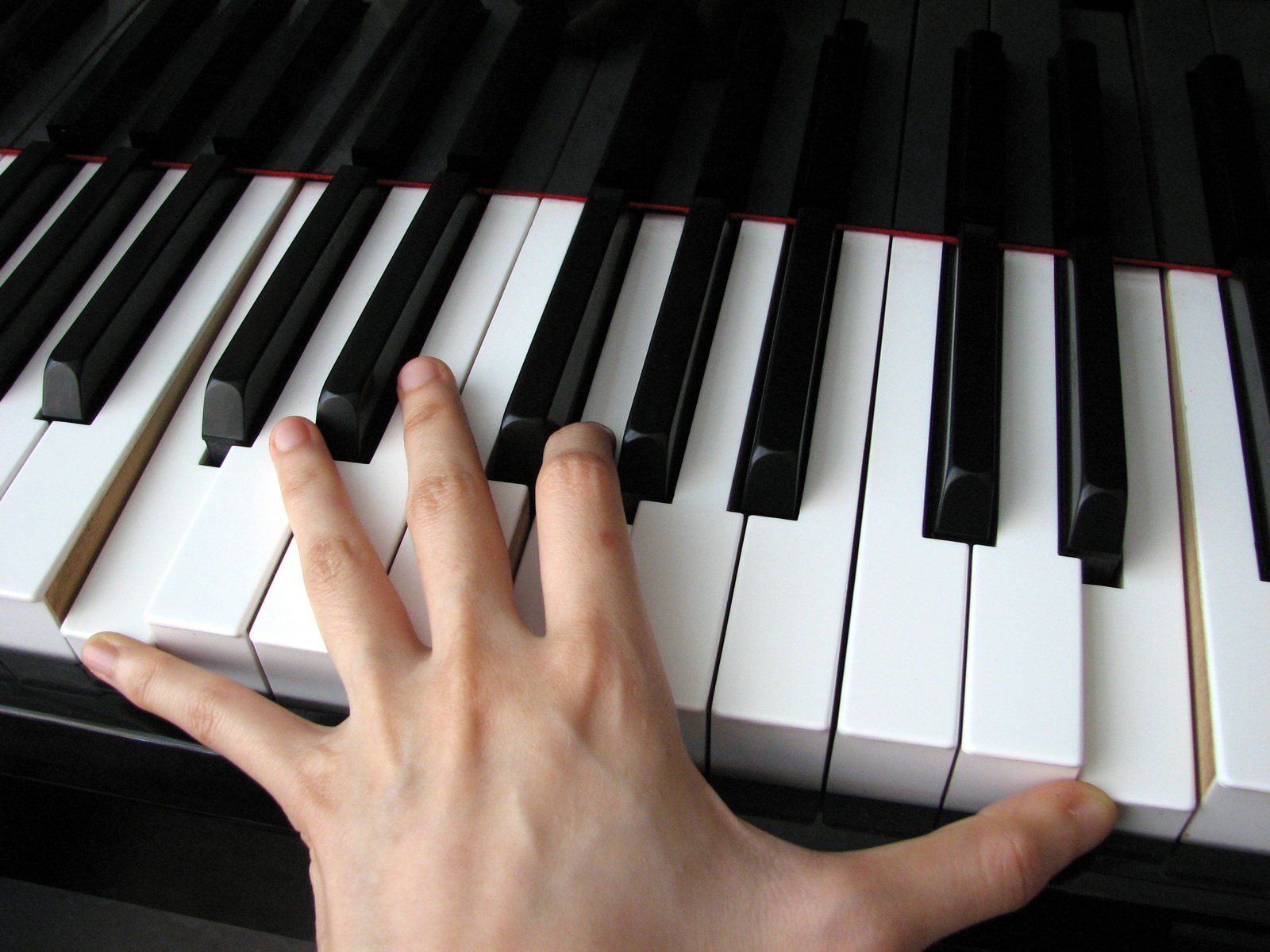 a hand is touching the keys of a piano