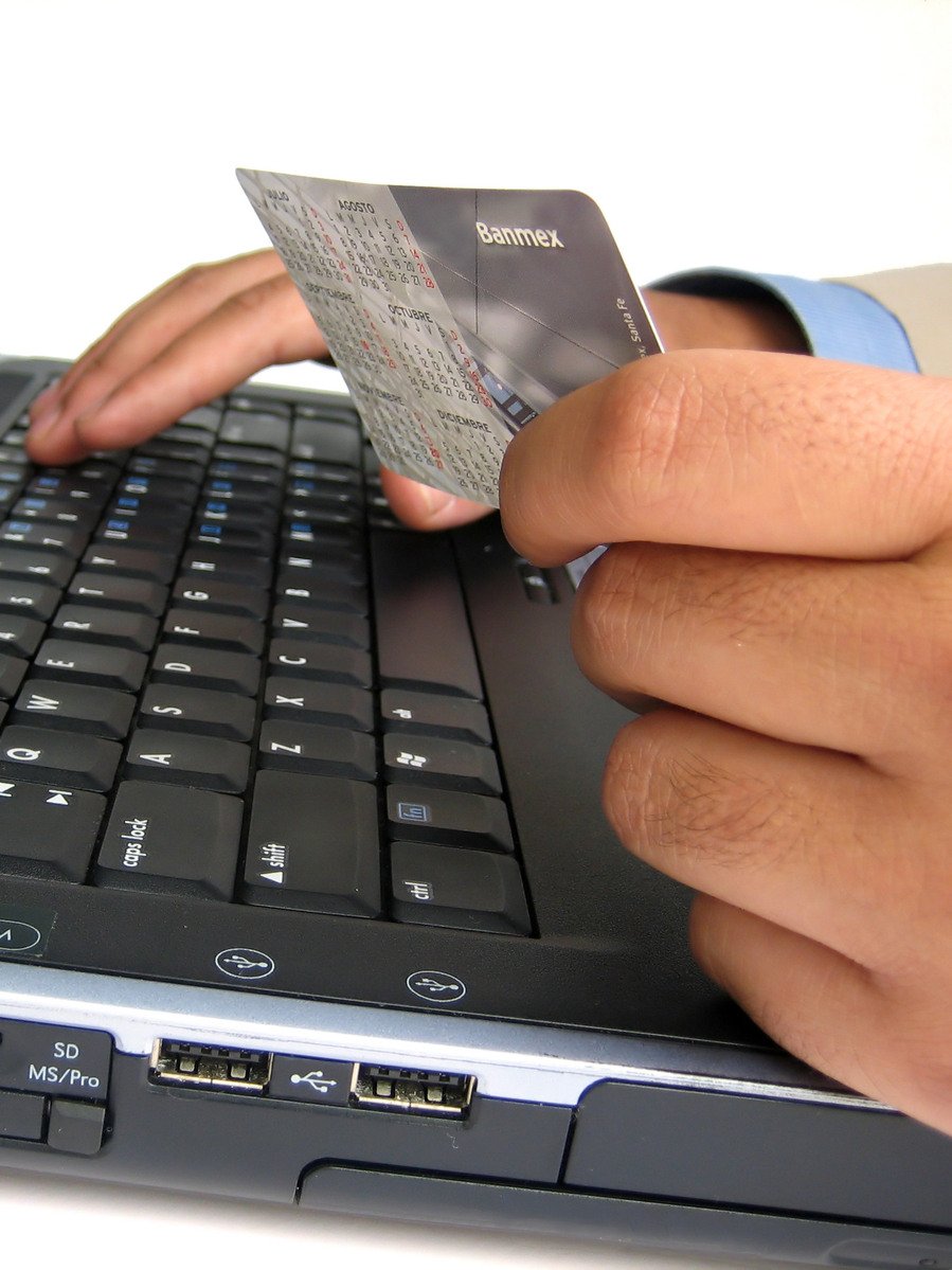 a person holding a small credit card on a laptop