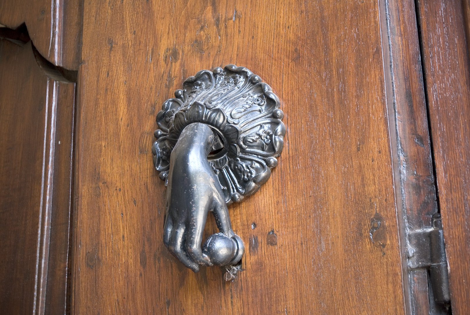 an old iron door handle is displayed on a wooden door