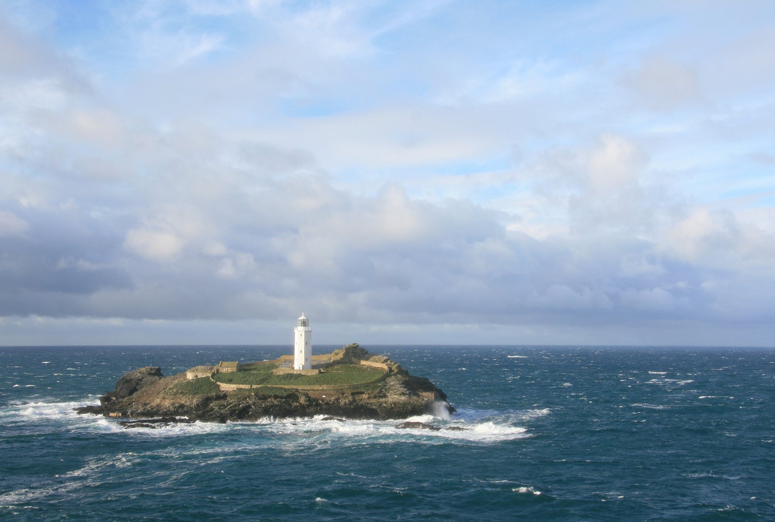 an island with a lighthouse is surrounded by the water