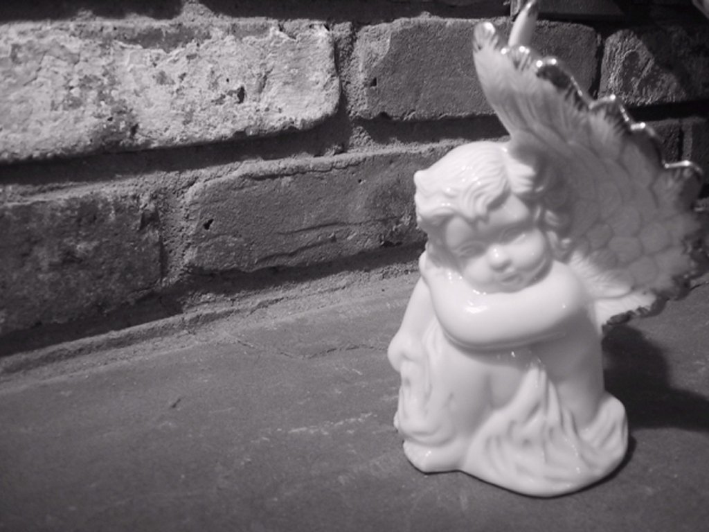 there is a ceramic angel ornament on the ground