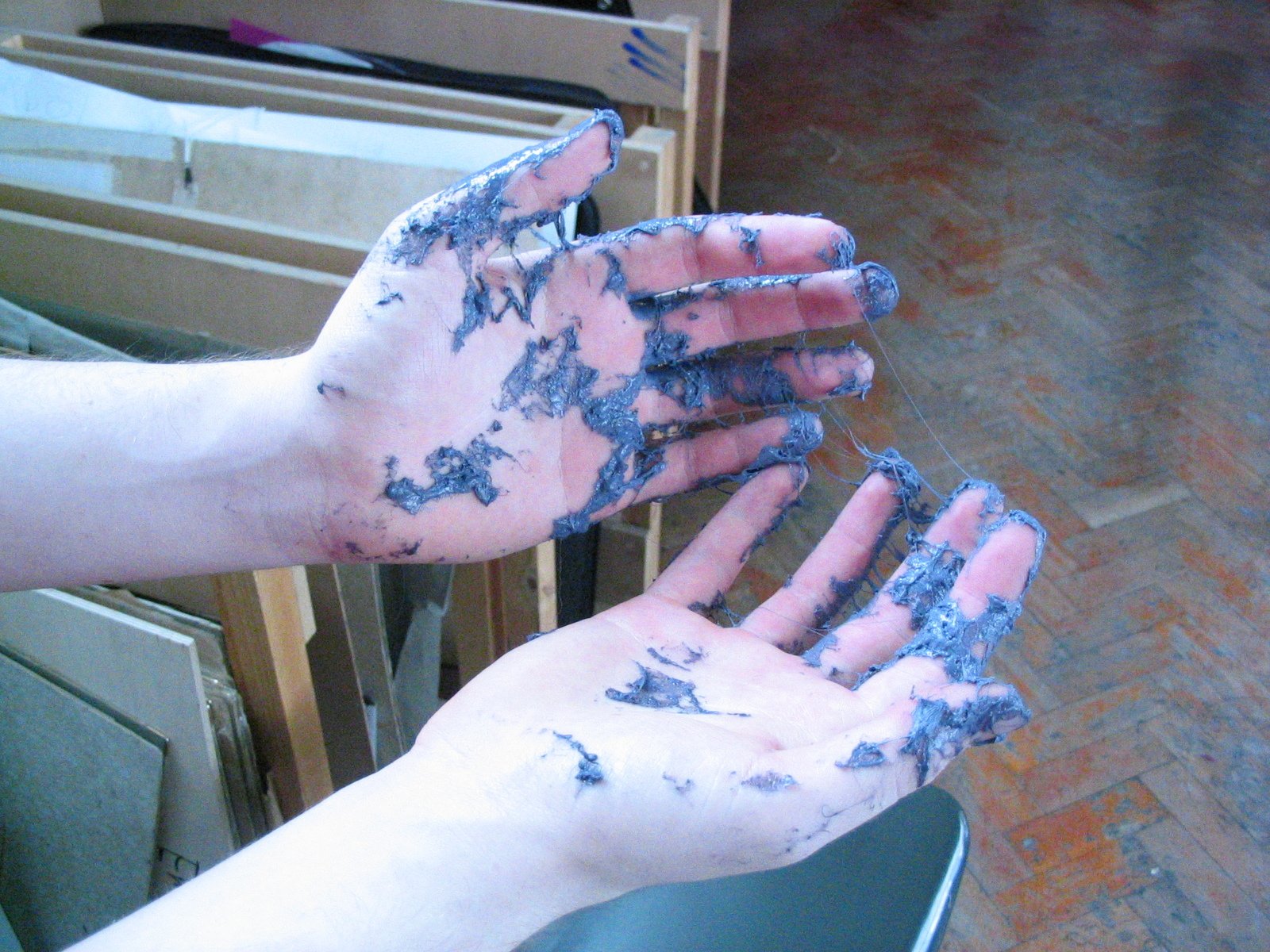 two hands are covered with dirty sand and siting on a chair