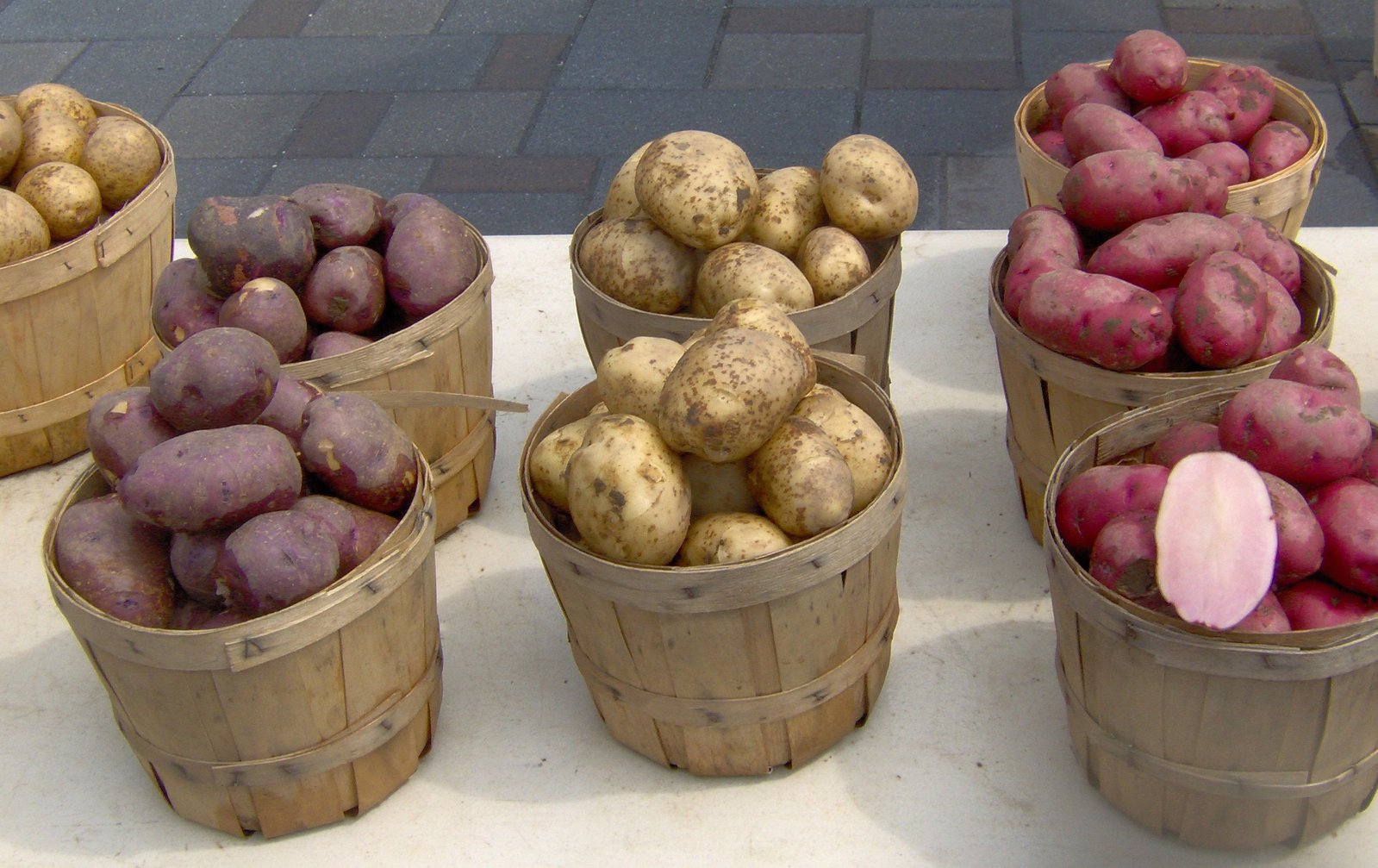 a couple of baskets full of purple potatoes