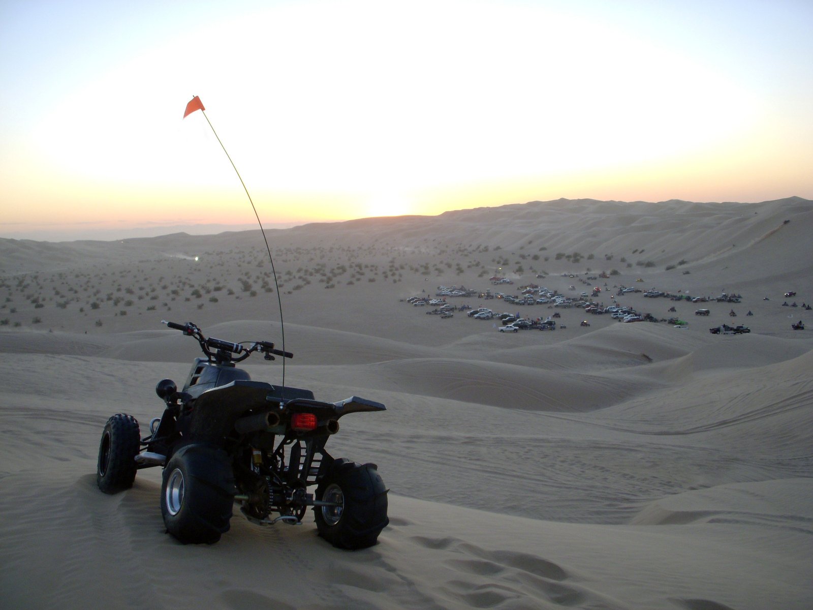 there is a motorcycle in the sand with a kite