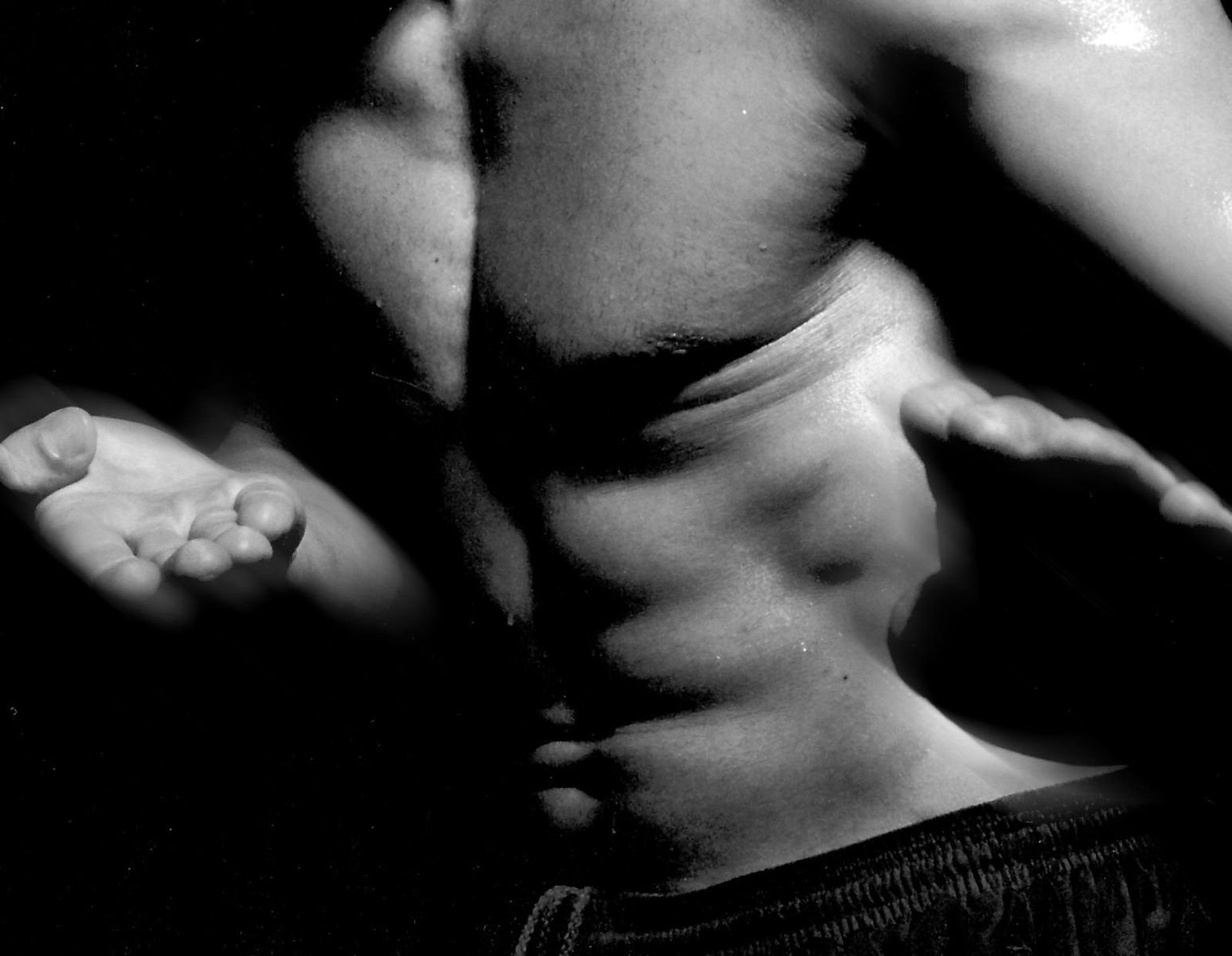 a close up of a man's shirtless body with one hand behind his back