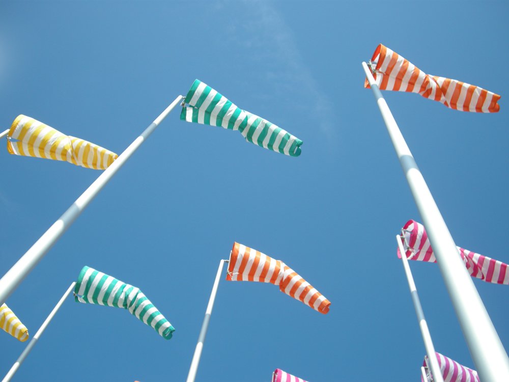 a row of striped flags are blowing in the wind