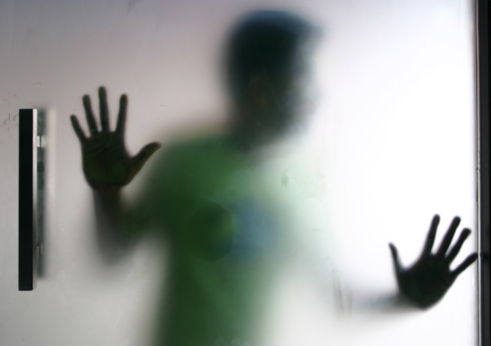 a blurry s of a silhouetted man holding a cellphone