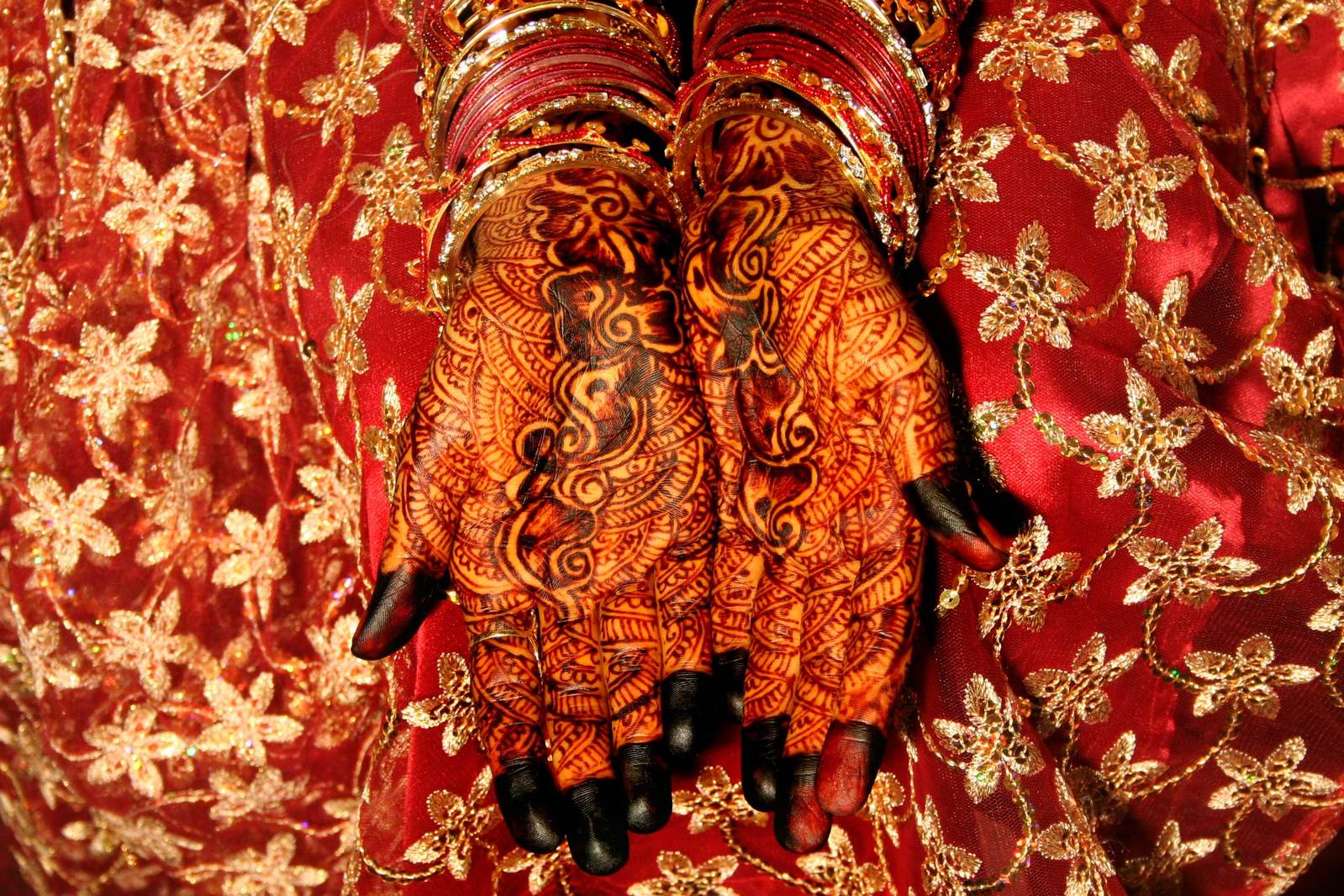 two hands that are holding a garment with designs