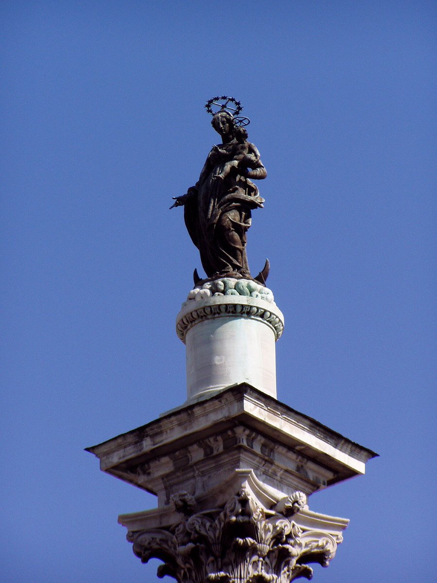 statue atop of a building that looks like it has a bird on its head