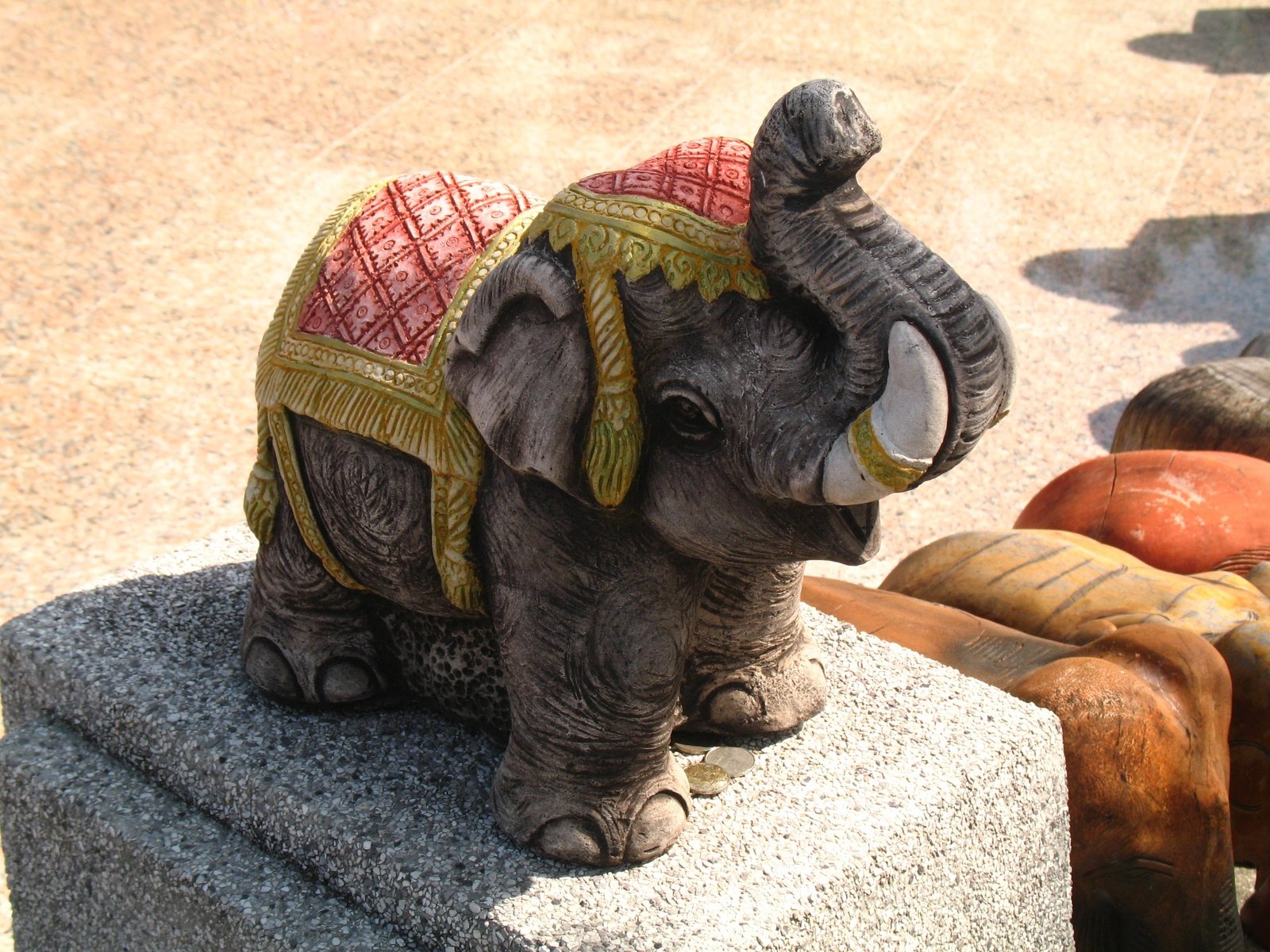 a statue of an elephant in a scarf on top of concrete blocks