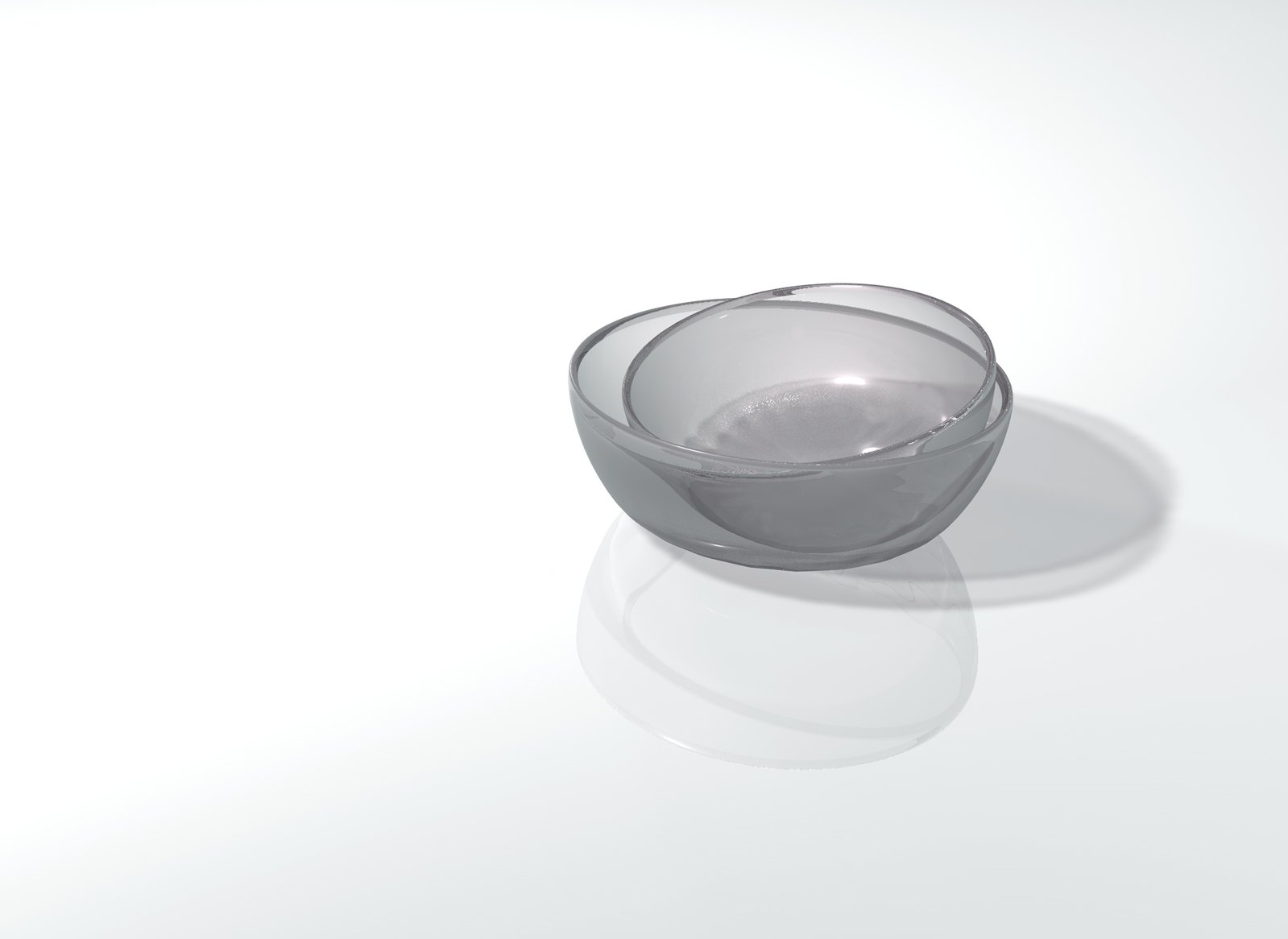 a clear bowl sits on top of a reflective surface