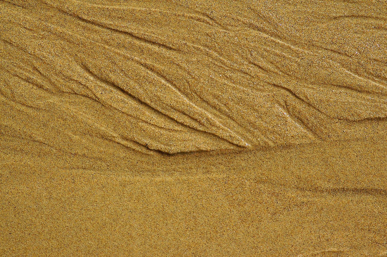 an image of the sand patterns made by water on the beach