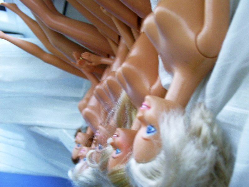 group of blonde dolls next to each other in white sheets