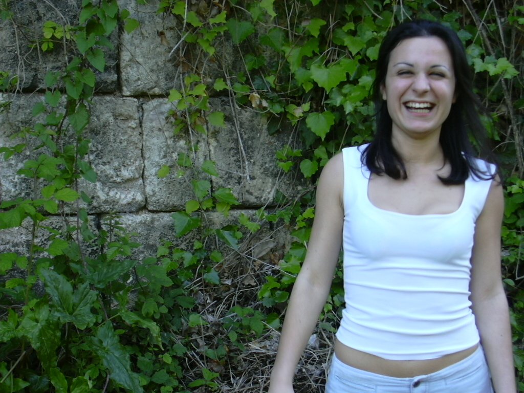 a woman is standing near a wall wearing no 