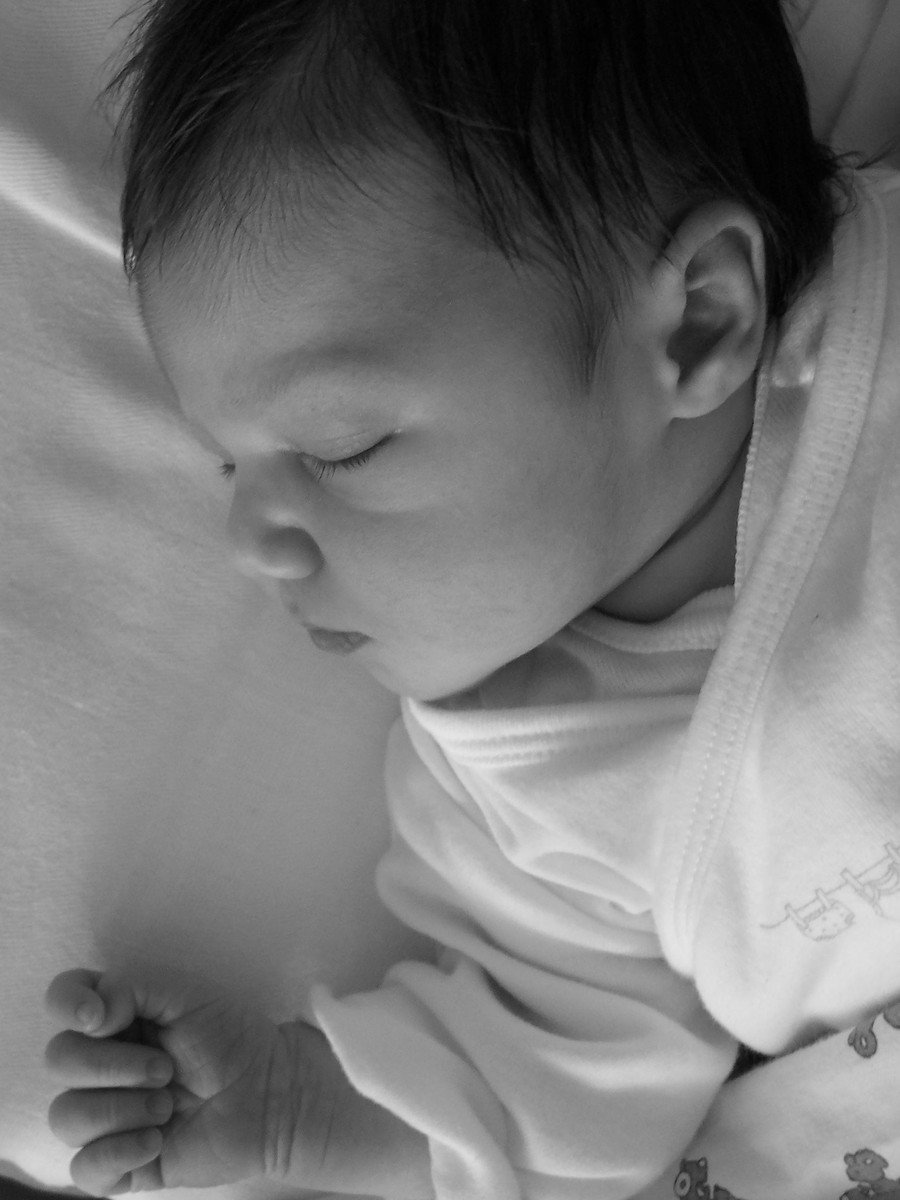 a black and white po of a baby on a bed