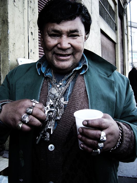 an older man smiling while holding a cup