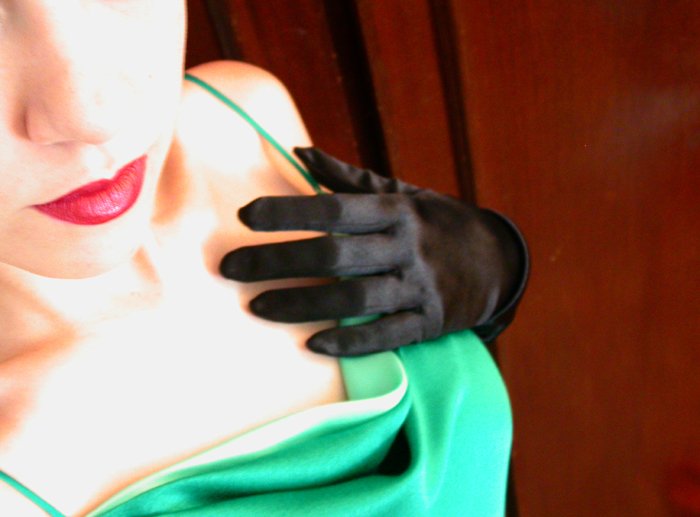 a woman wearing black gloves with a green shirt