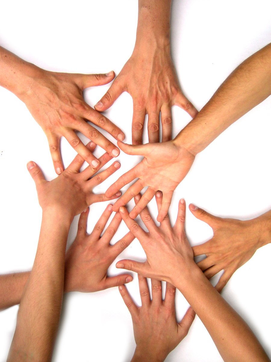 a group of hands reaching together with each other