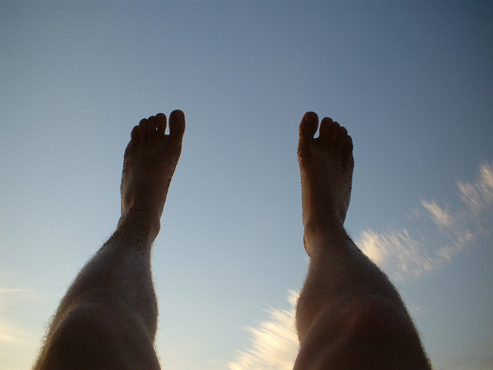 man's legs and feet with blue sky in background