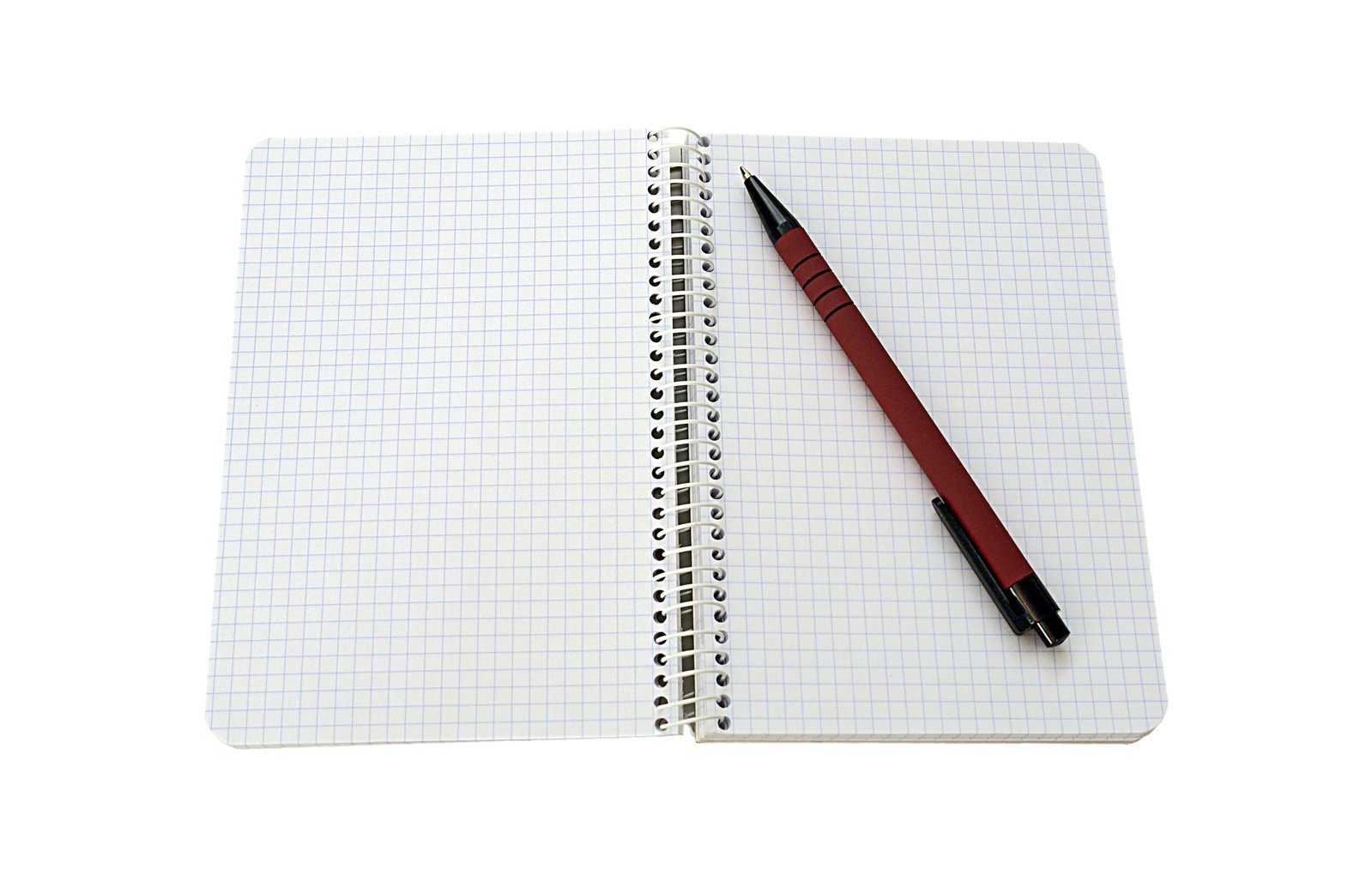 notebook and pen sitting on the edge of a white notepad