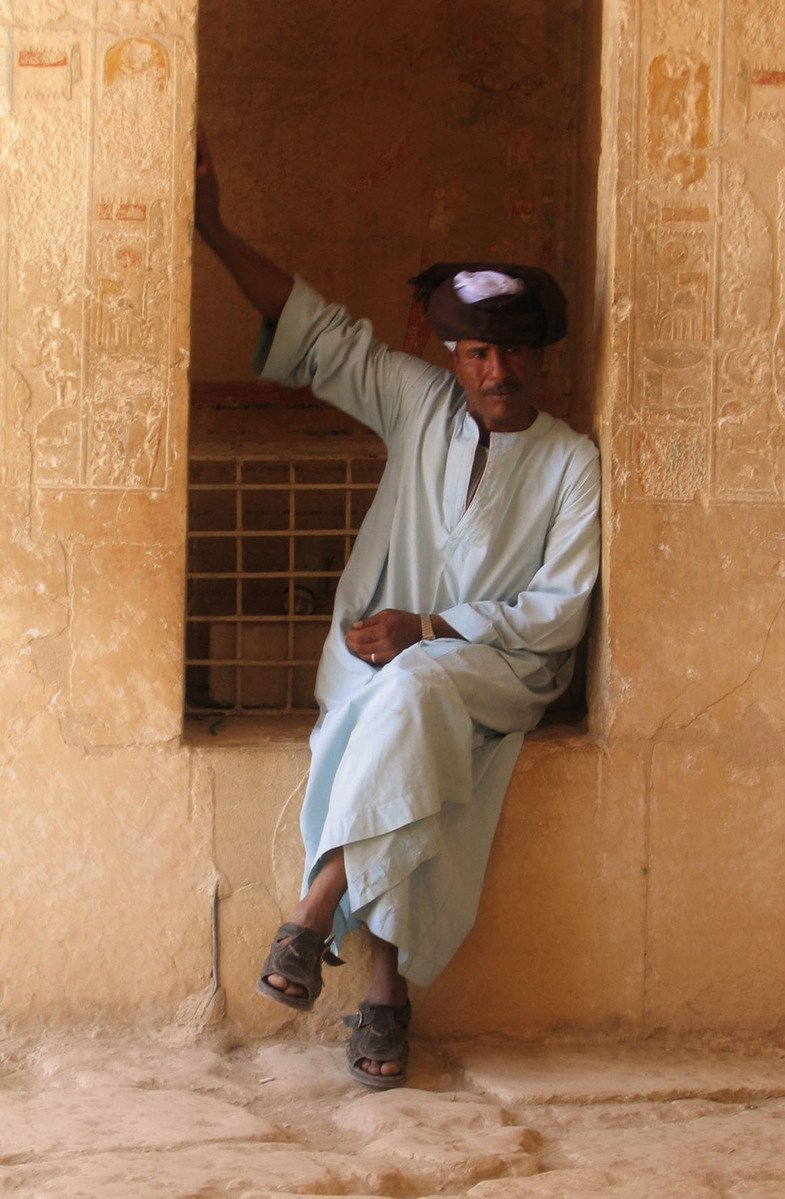 a man sitting on a wall next to a window