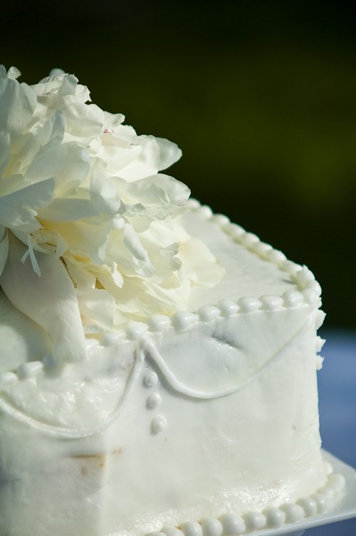 a white wedding cake with white flowers on top